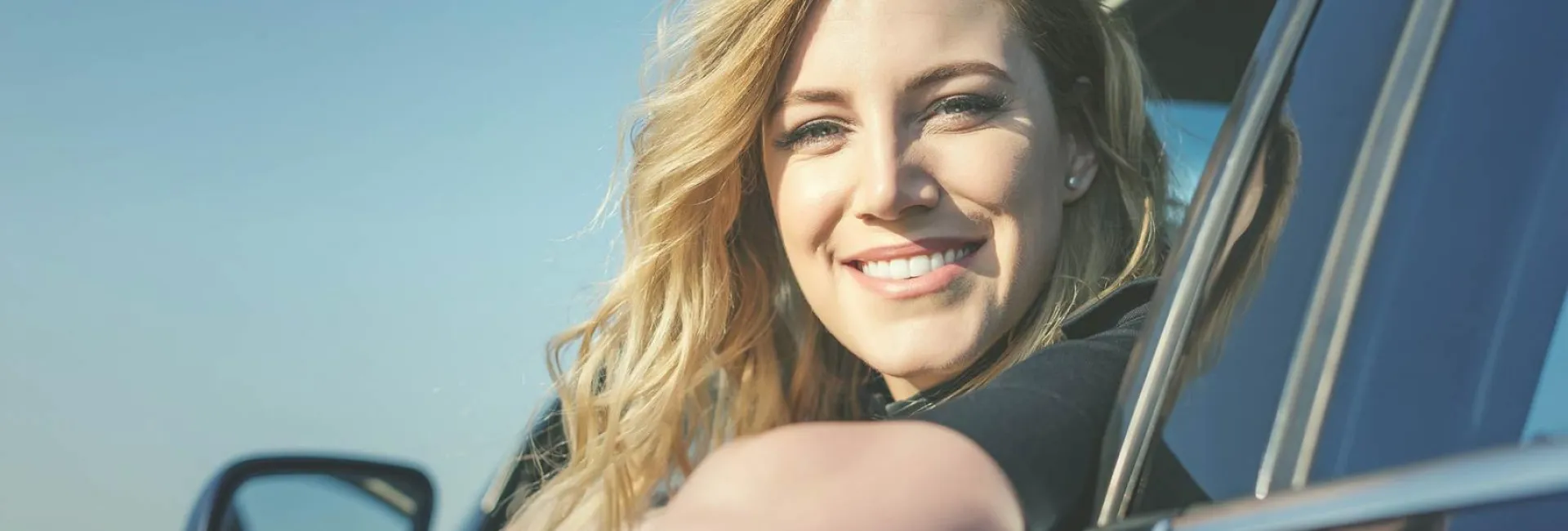 Freundliche Frau schaut aus PKW-Fenster